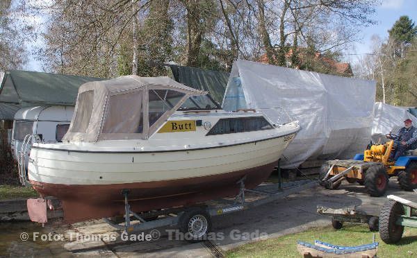 2012. Berlin. Zehlendorf. Wannsee. Bootshaus am Pohlesee. Das Motorboot Butt wird zu Wasser gelassen. Der Trailer rollt mit dem Boot zum Wasser.