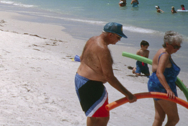 Senioren mit Schwimmnudeln am Strand